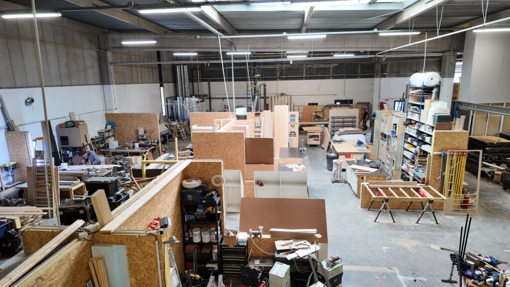 Vue de l’atelier Ateliers CRAAFT à Villeneuve d’Ascq, avec machines et établis.