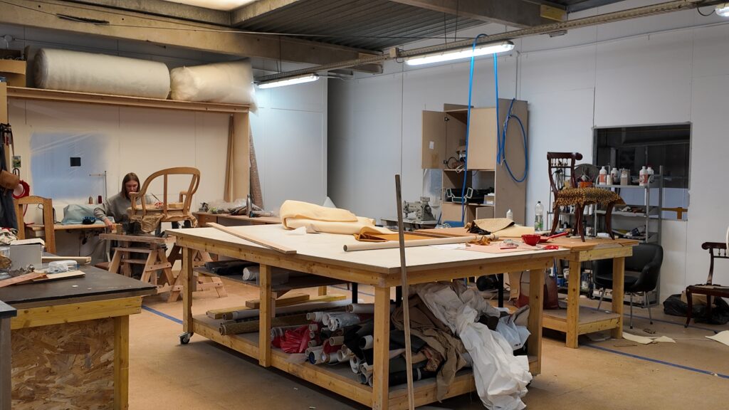 Vue de l’Atelier CRAAFT à Lille : travail de tapisserie artisanale avec restauration de chaises et couture main.