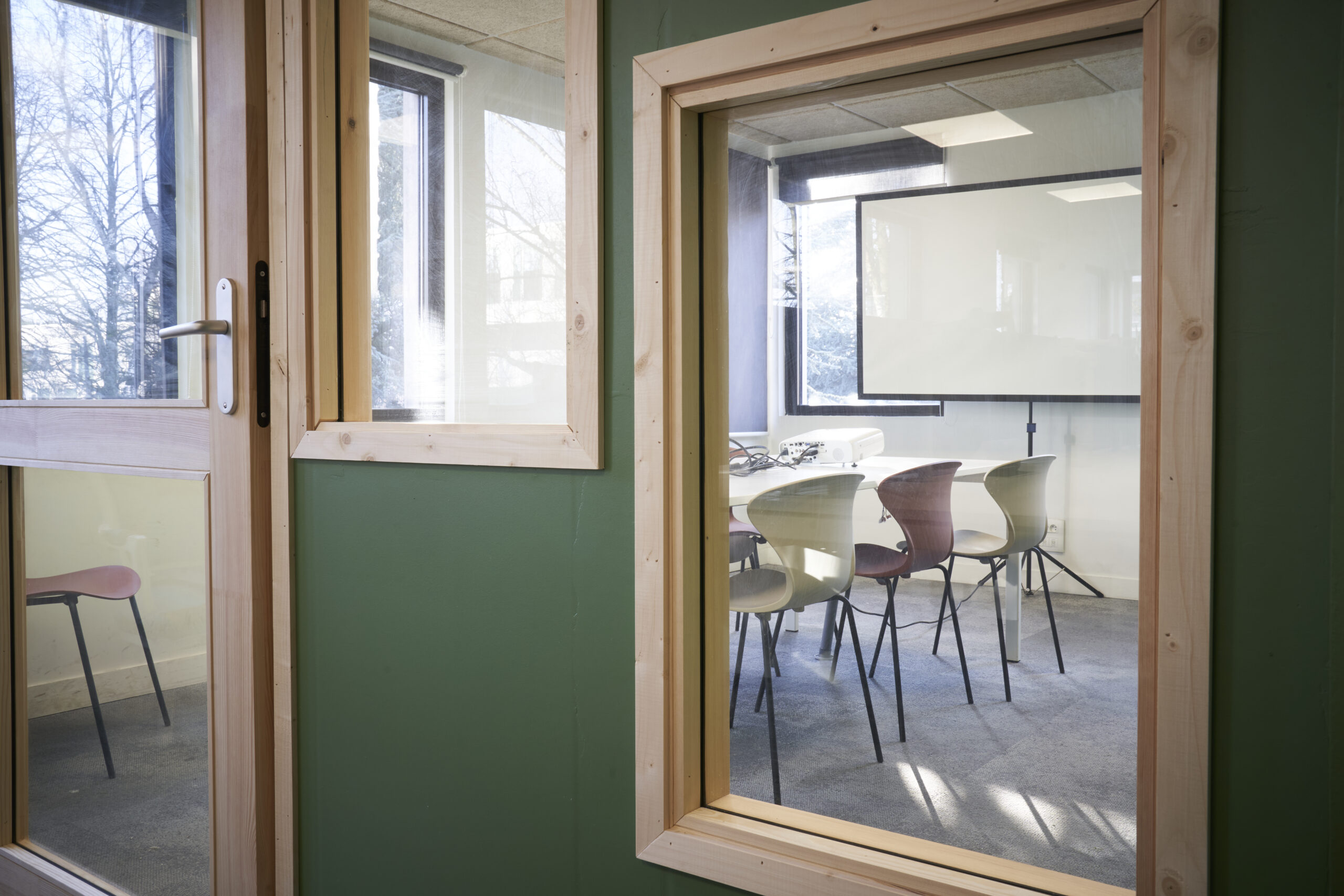 Salle de réunion visible depuis l’espace coworking de l’atelier CRAAFT à Lille