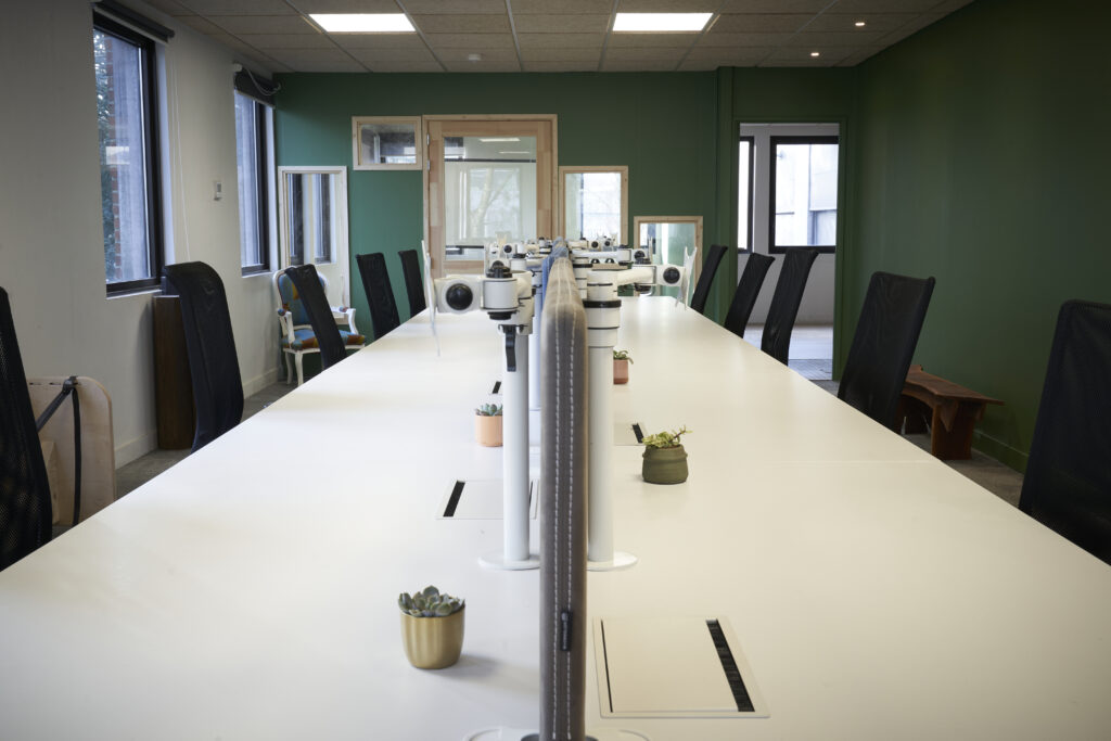 Grande table de coworking avec bureaux partagés dans l’espace de travail de l’atelier CRAAFT à Lille